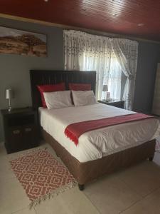 een slaapkamer met een groot bed en een raam bij KKK Guesthouse in Secunda
