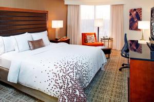 una habitación de hotel con una cama grande y una silla en Renaissance St. Louis Airport Hotel, en Saint Louis