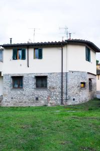 - un ancien bâtiment en pierre avec des fenêtres donnant sur un champ verdoyant dans l'établissement La Buca dei Sogni, à Fiesole