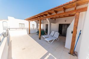 a patio with two white chairs and a wooden pergola at 2 bed, Kapparis, Trinidad - 2A in Paralimni