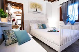 - une chambre avec un lit blanc et des oreillers bleus dans l'établissement La Buca dei Sogni, à Fiesole