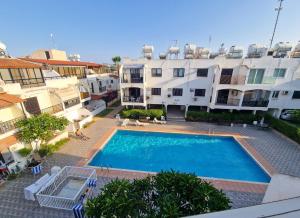 a swimming pool in front of some apartment buildings at 2 bed, Kapparis, Trinidad - 2A in Paralimni