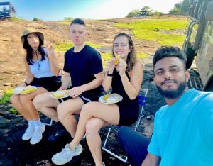 a group of people sitting in chairs eating food at Pearl White House in Udawalawe