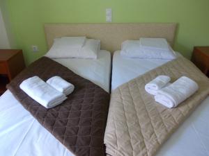 two beds in a room with white towels on them at Oneiro Studios in Loutra Edipsou