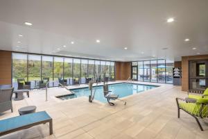 a pool in a hotel lobby with tables and chairs at Hampton Inn Hornell in Hornell