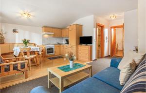 キルヒベルク・イン・チロルにあるAmazing Apartment In Kirchberg With 1 Bedrooms And Wifiのリビングルーム(青いソファ、テーブル付)