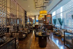 - un restaurant avec des chaises et une table dans une pièce dans l'établissement Hilton Bangkok Grande Asoke, à Bangkok