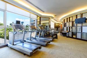 Hilton Bangkok Grande Asoke في بانكوك: صالة ألعاب رياضية مع صف من أجهزةالجري واجهزة الاوبتكال