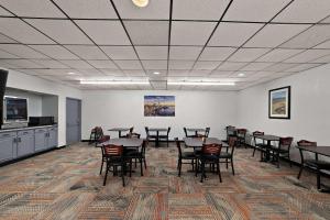 a large room with tables and chairs and a kitchen at Quality Inn & Suites in Caribou