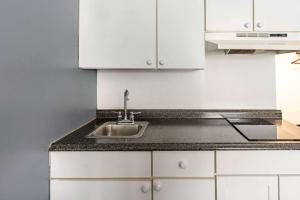 a kitchen with a sink and white cabinets at Quality Inn & Suites in Caribou