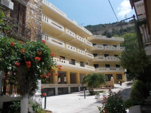 a large yellow building with flowers in front of it at Oneiro Studios in Loutra Edipsou