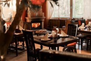 a restaurant with tables and chairs and a fireplace at Strandhotel Weißer Berg in Neustadt am Rübenberge