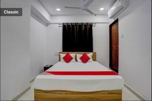 a bedroom with a large bed with red pillows at Hotel Green in Surat