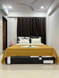 a bedroom with a large bed with a yellow blanket at Hotel Green in Surat