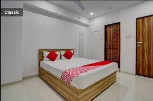 a bedroom with a large bed with red pillows at Hotel Green in Surat
