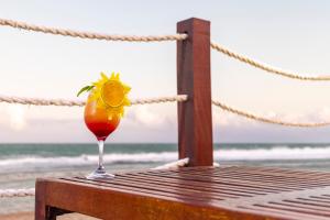 a drink sitting on a table next to the beach at Flat Beach Class Muro Alto - Porto de Galinhas 02 Quartos in Porto De Galinhas