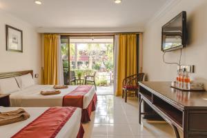 a hotel room with two beds and a desk at Pangkor Sandy Beach Resort in Pangkor