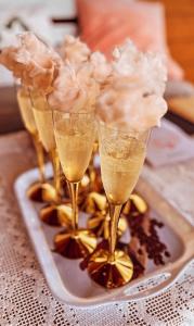 a tray with four champagne glasses with flowers on it at Poleskie zacisze, domek Bocian, kominek, balia,sauna,wifi in Helenin