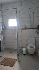 a white bathroom with a toilet and a window at כוכב הגלבוע in Gan Ner