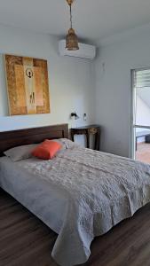 a bedroom with a large bed with an orange pillow at כוכב הגלבוע in Gan Ner