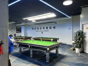 a man standing in a room with a pool table at Annie 公寓-2602 in Kunming