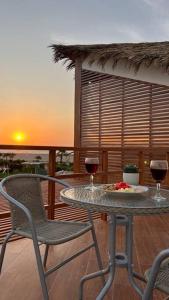 a table and two glasses of wine on a balcony at Hermosa casa con vista al mar in Casa Blanca
