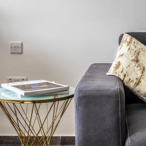 a side table with a book on it next to a couch at Spinola Studio Deluxe, StJulians in St Julian's