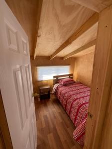 1 dormitorio con 1 cama en una habitación pequeña en Cabañas Maldonado, en Hornopirén