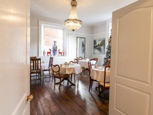 a dining room with tables and chairs and a chandelier at 3 Old Market Place in Harleston