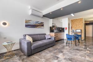 ein Wohnzimmer mit Sofa und Tisch in der Unterkunft Spinola Studio Deluxe, StJulians in St Julian's + 21 Fotos