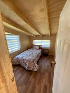 1 dormitorio con 1 cama en una casa pequeña en Cabañas Maldonado, en Hornopirén