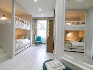 a bedroom with two bunk beds and a blue chair at 3 Old Market Place in Harleston