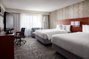 a hotel room with two beds and a flat screen tv at Courtyard Milpitas Silicon Valley in Milpitas +23 photos