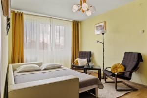 1 dormitorio con 1 cama, 1 silla y 1 ventana en The Cloud, Free Early Check-In Available, en Bucarest