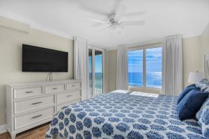 a bedroom with a bed with a tv and a dresser at Island Princess 710 in Fort Walton Beach