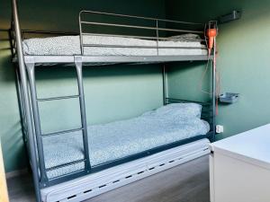 pokój z łóżkiem piętrowym z 2 łóżkami piętrowymi i ręcznikami w obiekcie La Cabane de la mer w mieście Bredene