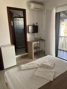 a bedroom with a bed with two towels on it at Quinta Da Bica D'Agua Village in Florianópolis