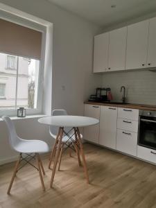 uma cozinha com mesa e cadeiras num quarto em Apartament SKALNIAK em Kudowa-Zdrój