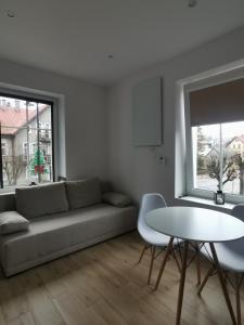 uma sala de estar com um sofá e uma mesa em Apartament SKALNIAK em Kudowa-Zdrój
