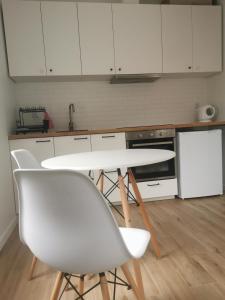 uma cozinha com uma mesa branca e cadeiras em Apartament SKALNIAK em Kudowa-Zdrój