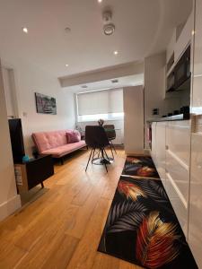 ein Wohnzimmer mit einem rosa Sofa und einem Teppich in der Unterkunft Modern 1 bedroom apartment in the center of Croydon in Croydon