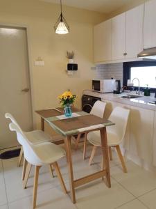a kitchen with a wooden table and chairs and a kitchen with a sink at Happy Family Horizon Suite - near Xiamen-KLIA Netflix in Kampong Melot