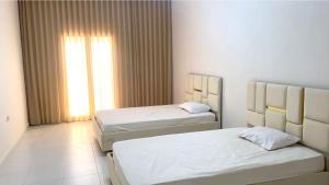 1 dormitorio con 2 camas y ventana en Modern Apartment High Standards en Monastir