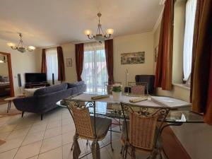 sala de estar con mesa y sofá en Appartement Kastelo Teraso, en Zalacsány