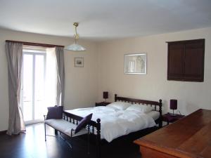 una camera con un letto e una sedia e una finestra di Casa Perini a Tenero-Contra