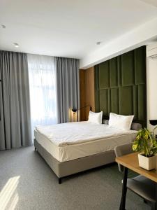 a bedroom with a large bed and a table at Evropa Hotel in Bishkek