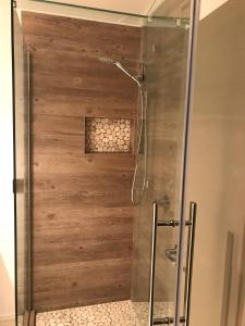 a shower with a wooden wall in a bathroom at Garden Oasis in the heart of Pāpāmoa in Tauranga