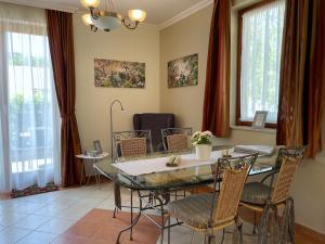 comedor con mesa de cristal y sillas en Appartement Kastelo Teraso en Zalacsány