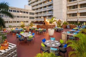 an outdoor patio with tables and chairs on a building at Four Points by Sheraton Dar es Salaam New Africa in Dar es Salaam