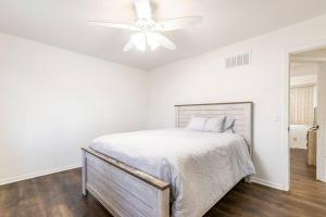 a white bedroom with a bed and a ceiling fan at SmartHome- Omaha Homestay with EV Charging in Omaha